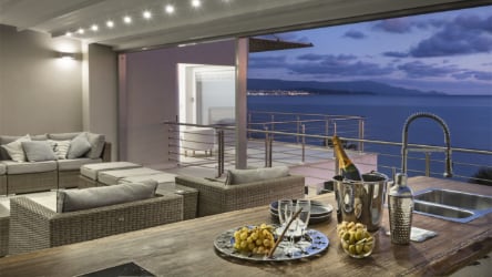 a modern terrace overlooking the sea, with food on a table